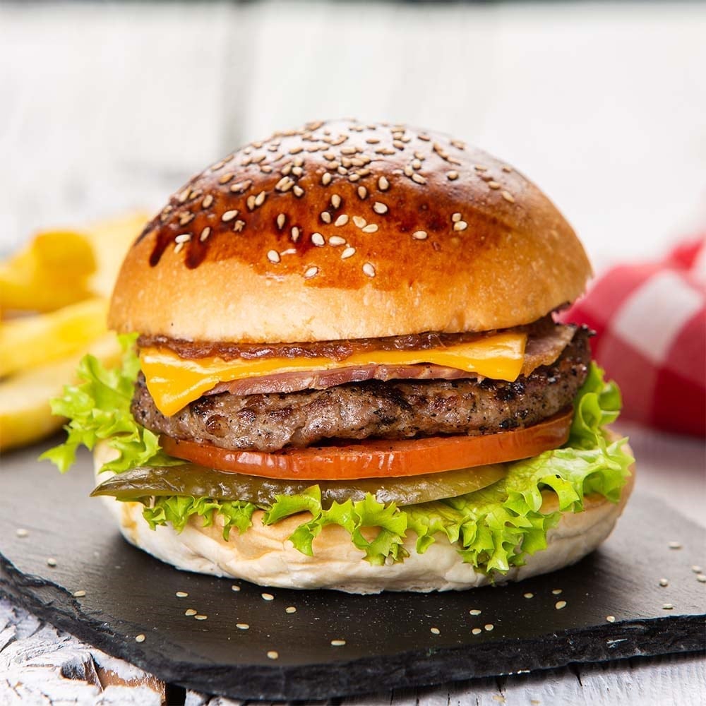 Izgara köfte, peynir ve taze yeşilliklerle köfte burger