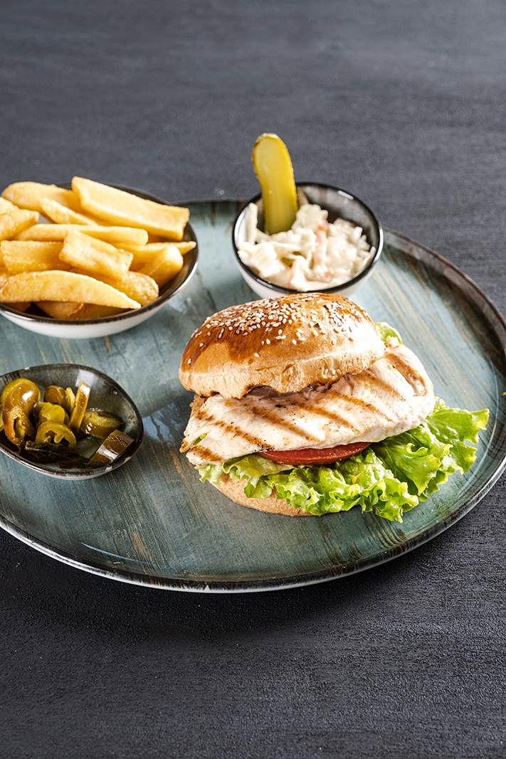 Susamlı ekmek, çıtır tavuk, taze yeşillik ve sosla tavuk burger